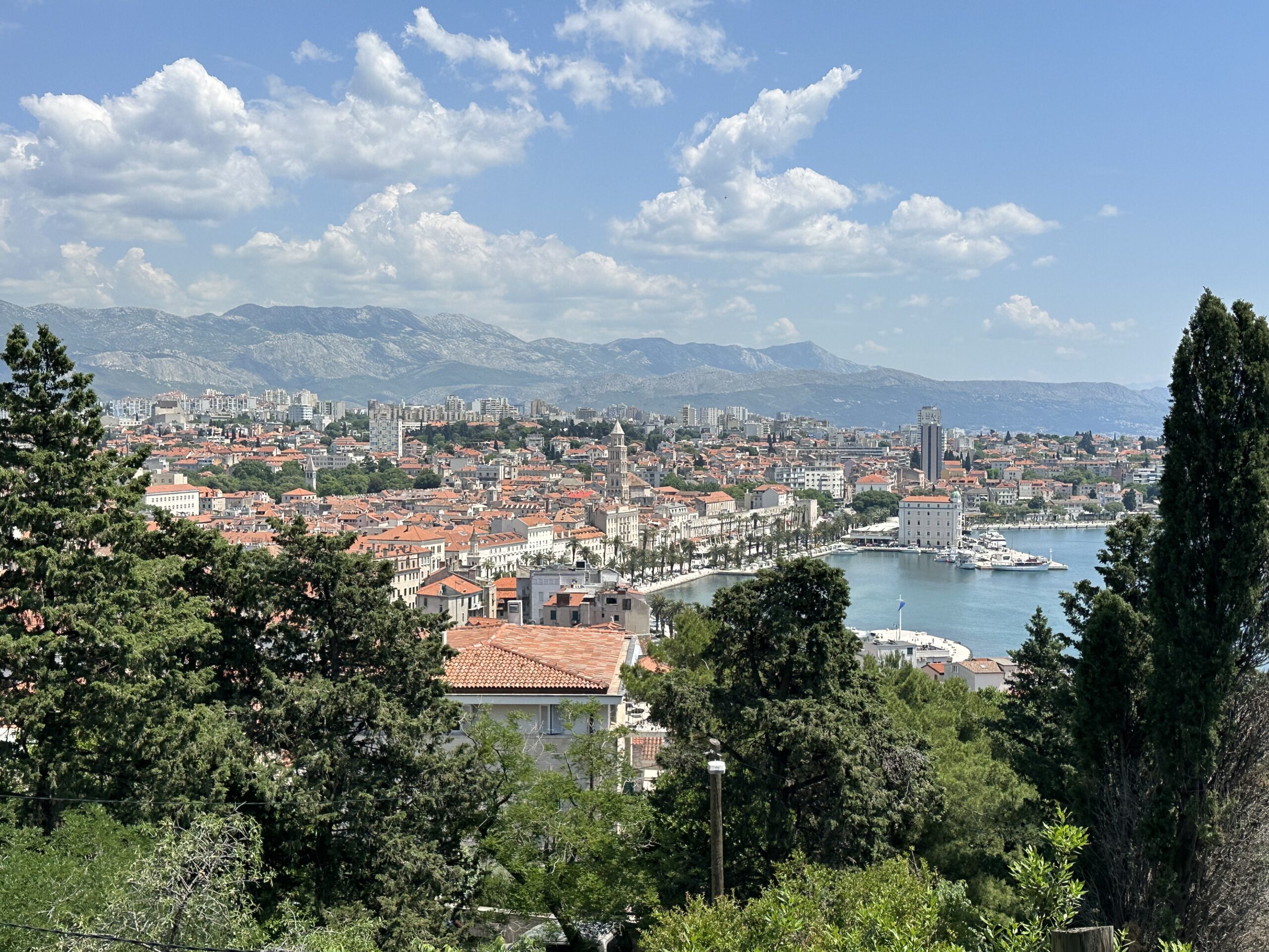 View of Split, Croatia from above, with red rooftops and the harbour along the Adriatic Sea.