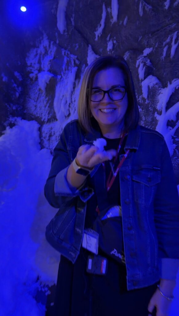 Amy Urquhart holding snow inside the blue-lit snow grotto in the Viking Mars Nordic Spa.