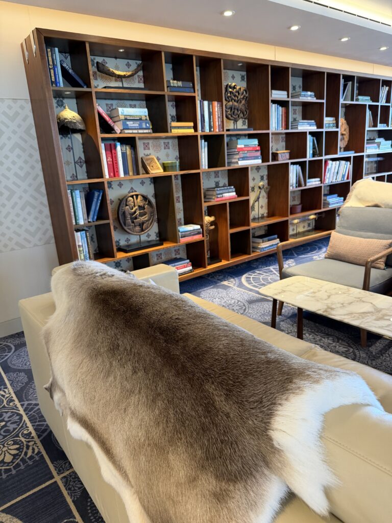 Viking Mars lounge with bookshelves, Nordic decorative pieces and a sofa draped with a fur-like throw.