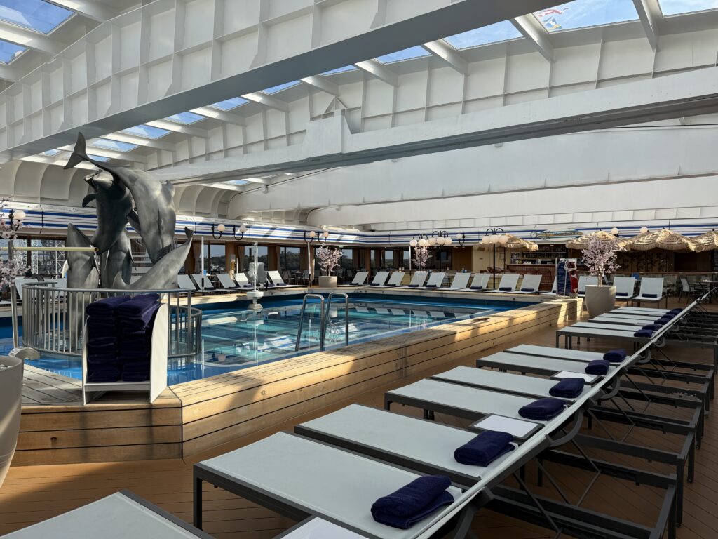 Lido pool aboard Holland America Line Volendam with retractable glass roof and surrounding loungers
