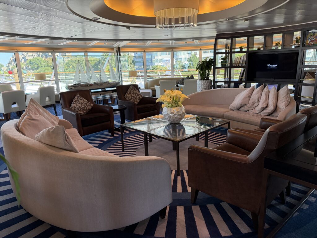 cruise ship lounge with comfortable chairs and surrounding windows